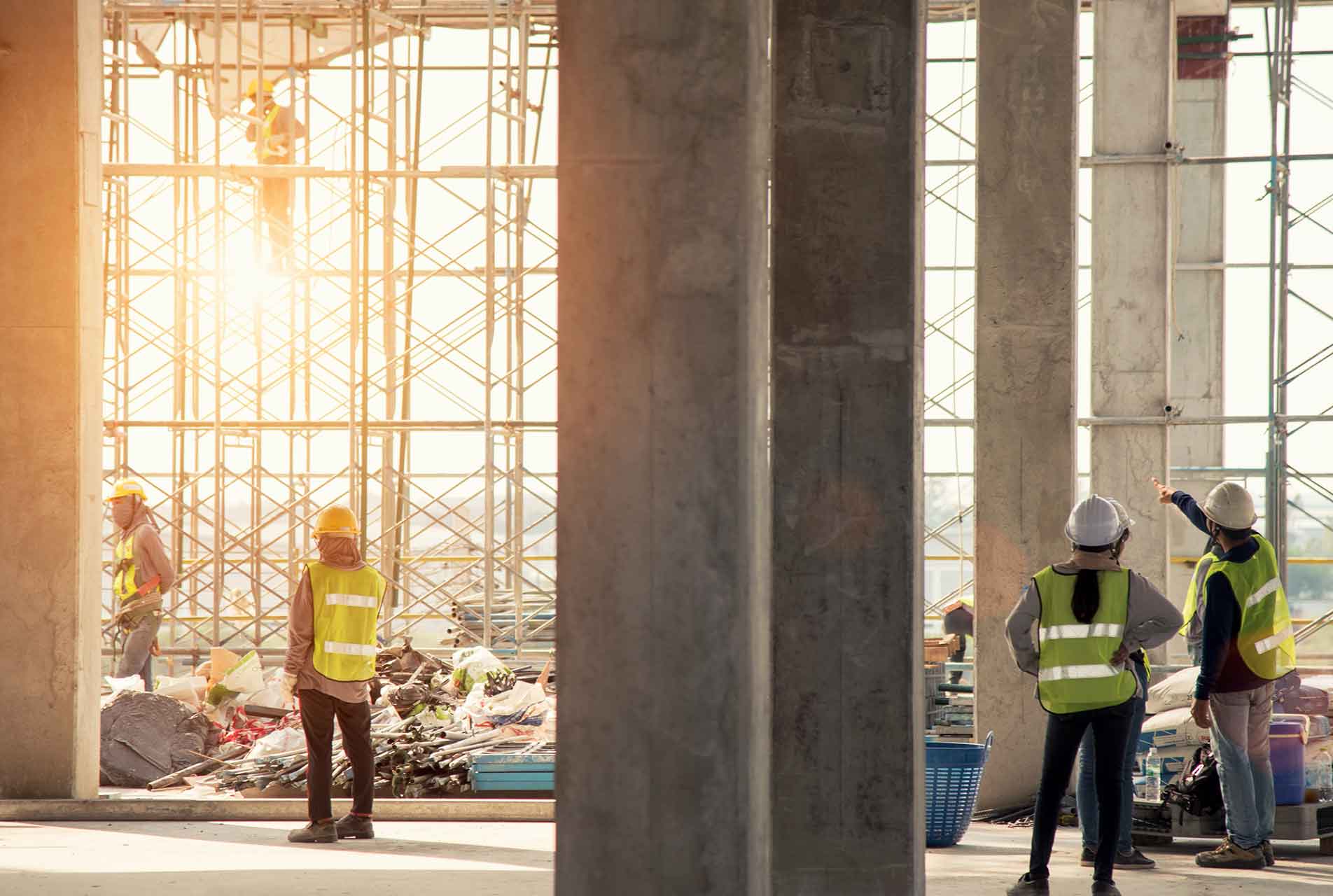 Bauarbeiter auf einer Baustelle bei Sonnenuntergang