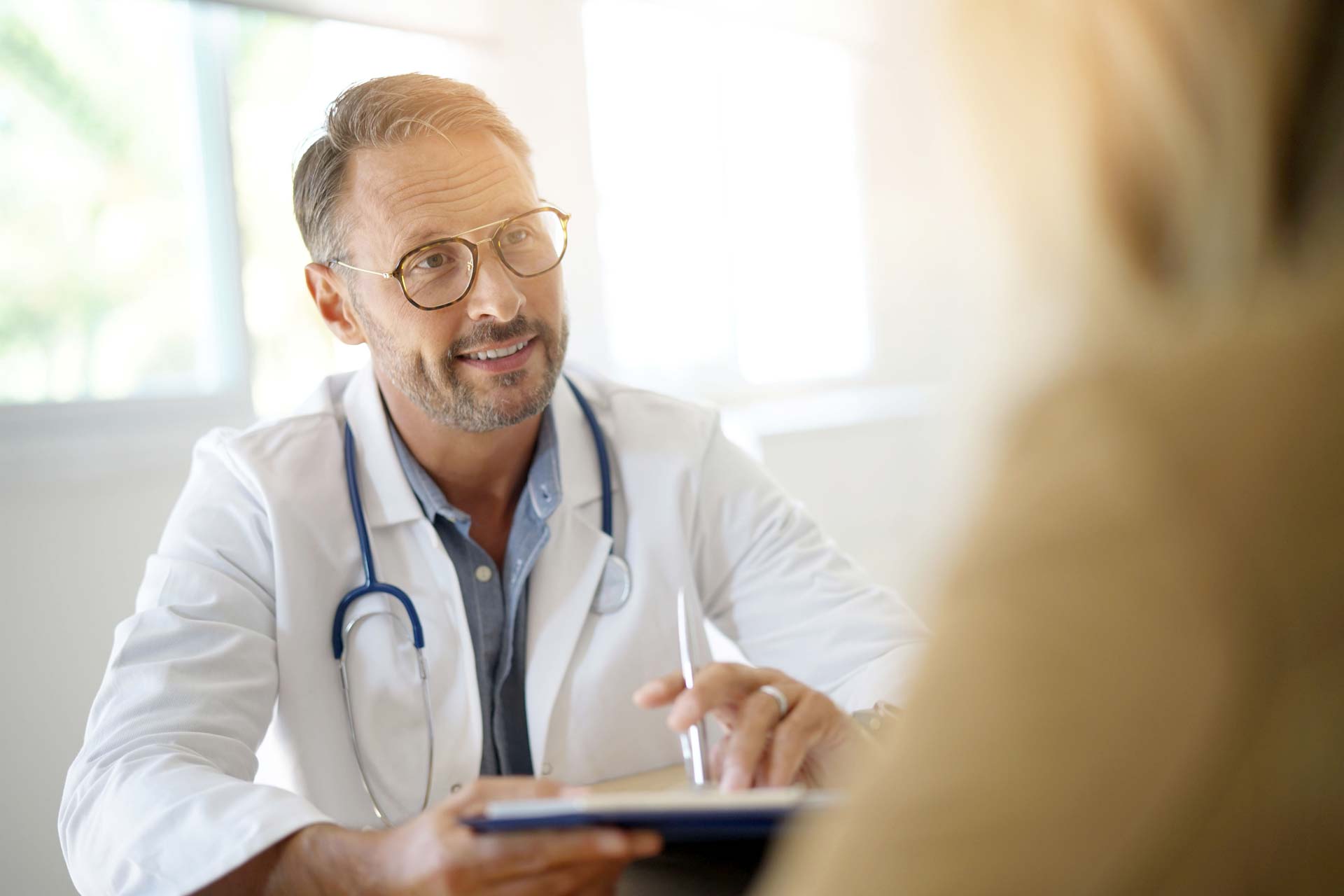Arzt spricht mit Patientin im Büro