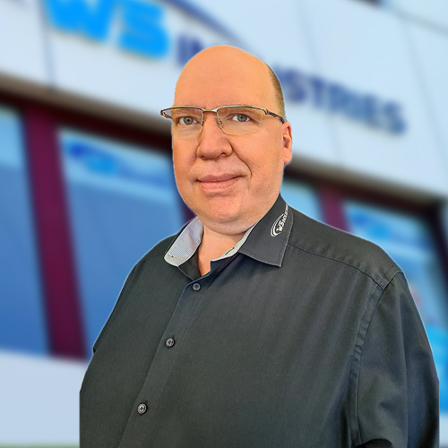 Mann vor Firmenlogo lächelt