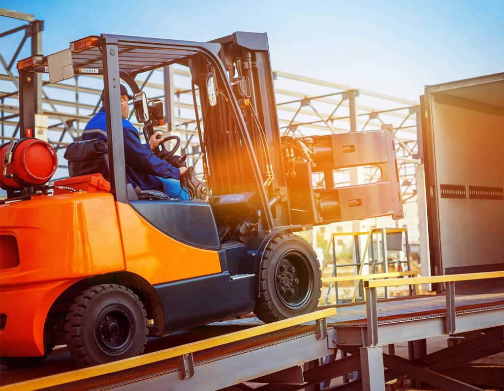 Gabelstapler lädt Kisten bei Sonnenuntergang