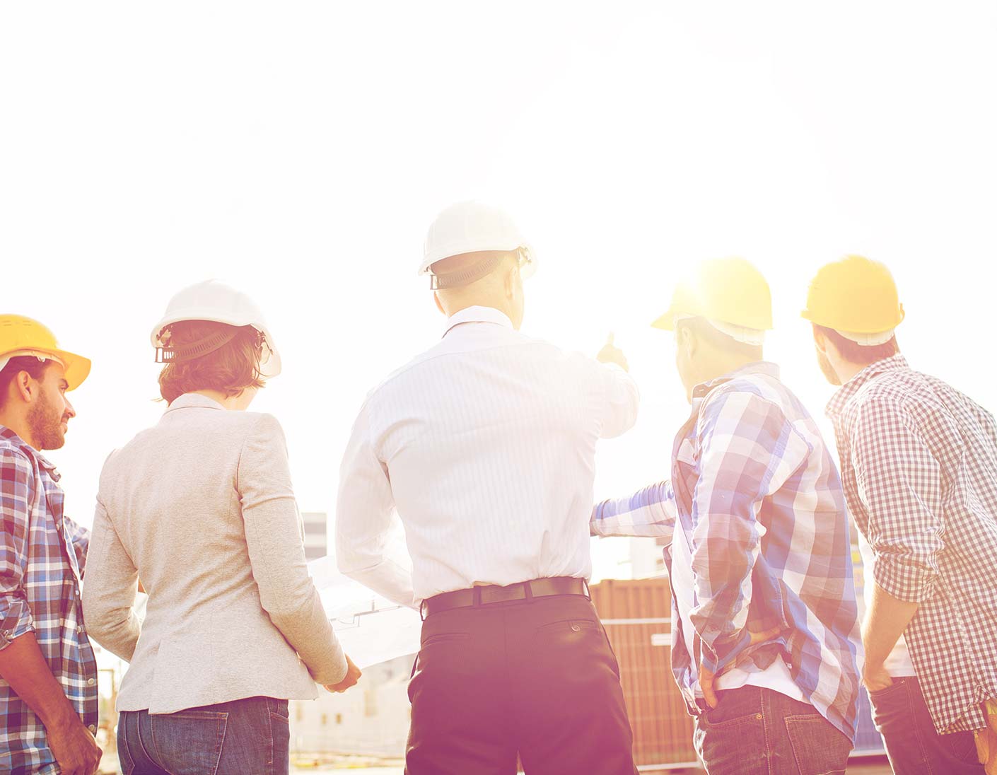 Ingenieure diskutieren auf Baustelle im Sonnenlicht
