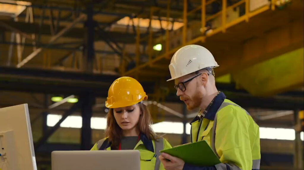 Ingenieure diskutieren über Laptop in Fabrik