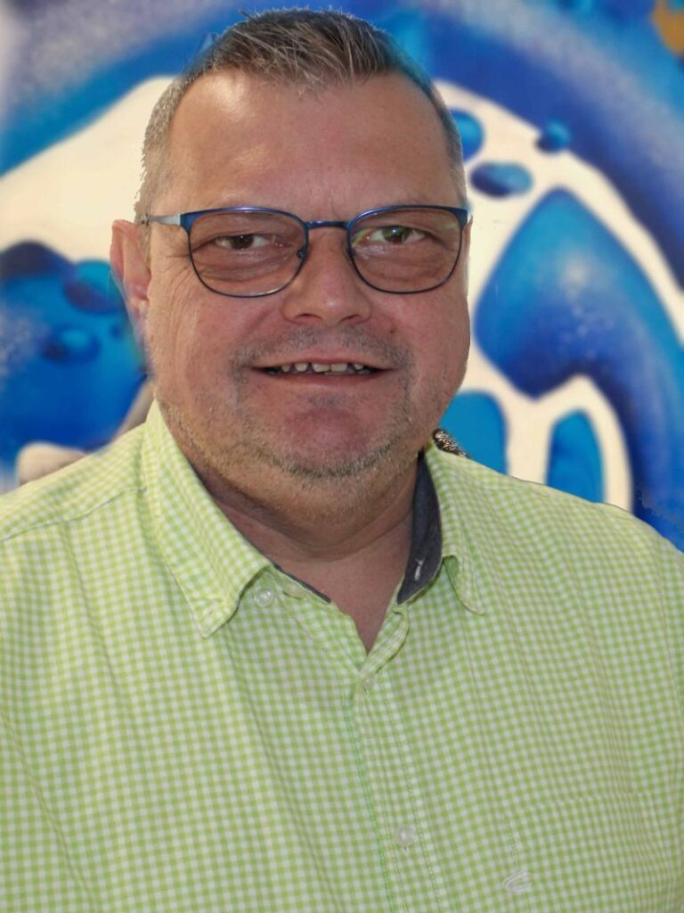 Mann mit Brille vor abstraktem blauem Hintergrund