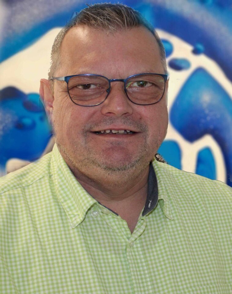 Mann mit Brille vor abstraktem blauem Hintergrund