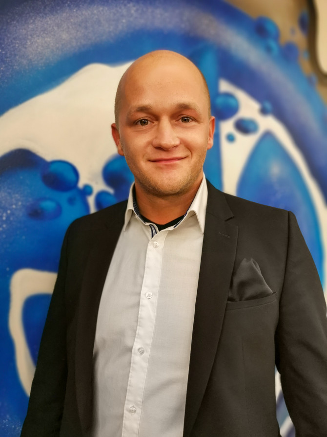 Mann in Anzug vor blauem Kunstwerk