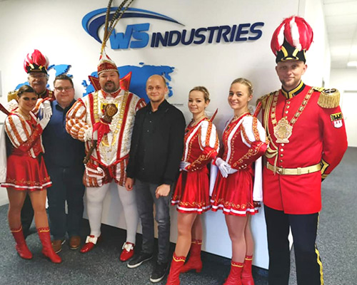 Gruppe in Karnevalskostümen mit Mann in Geschäftskleidung